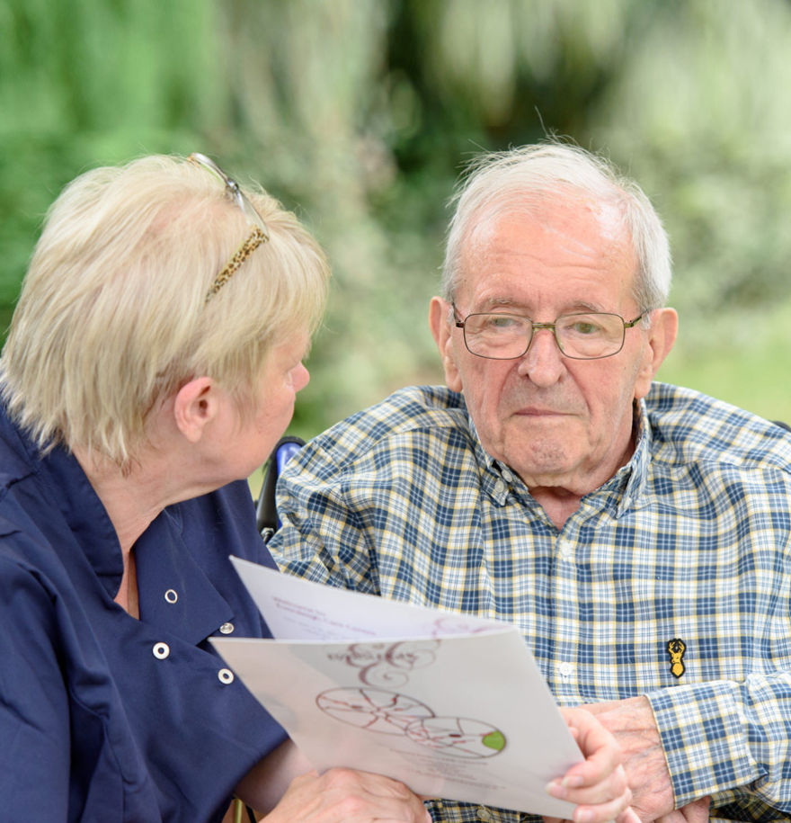 team member looking at brochure with male resident