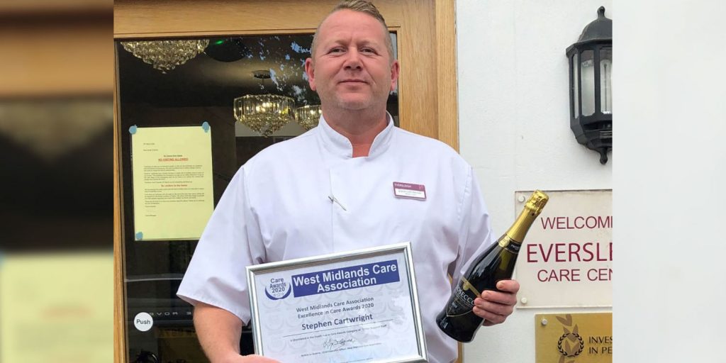 stephen cartwright holding west midlands care association certificate and champagne
