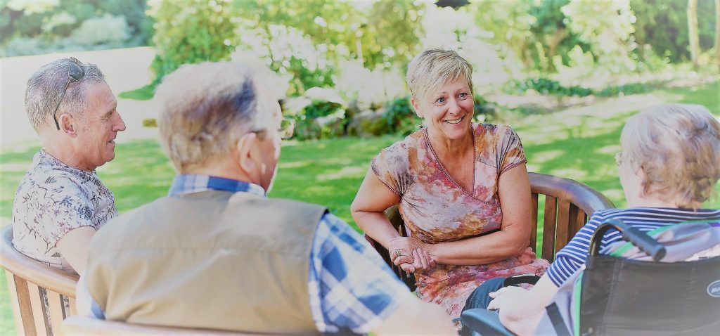 family members and resident talking in the garden