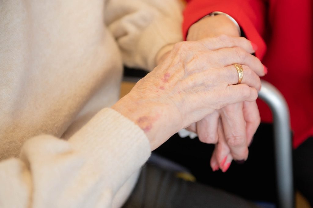 two elderly women holding hands