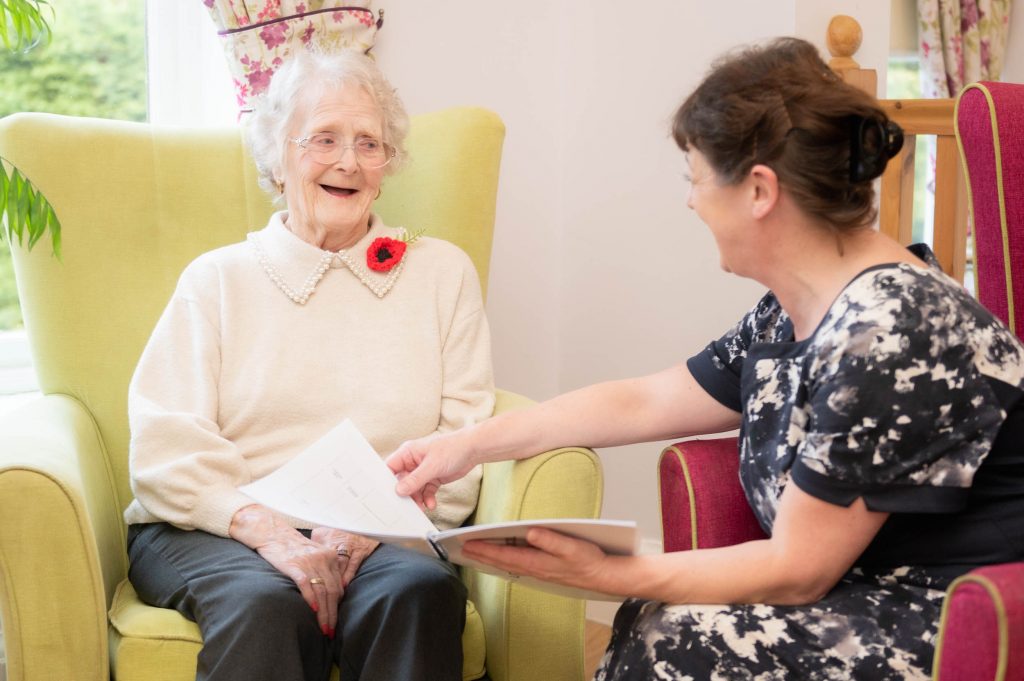 home manager and resident sitting down and laughing together